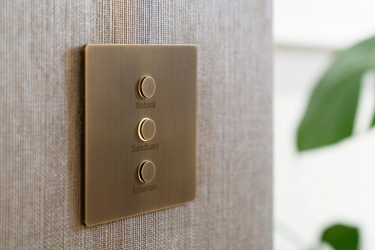 Lutron Alisse keypad in brass on a textured wall